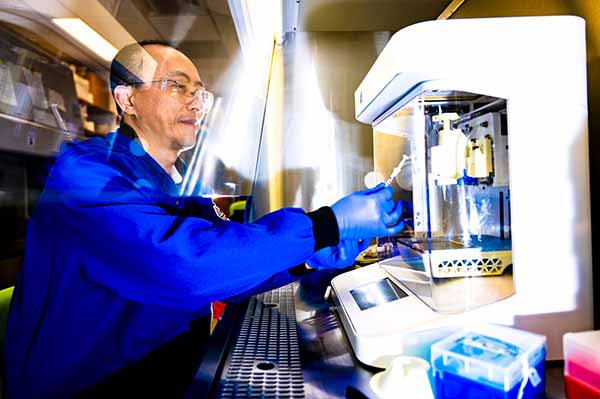 professor in lab working with 3D printer