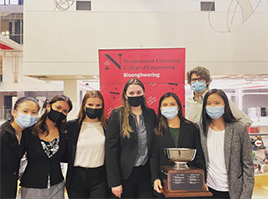 student capstone team with winning cup