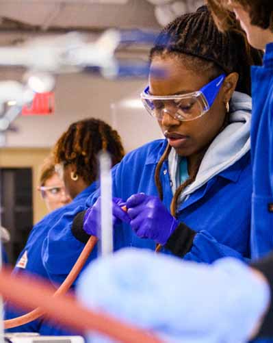 student working in biology lab on table with other students