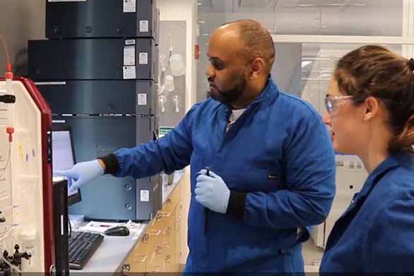 male and female students in lab attire working in bioengineering lab