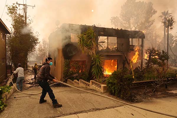 firefighter with hose during burning house