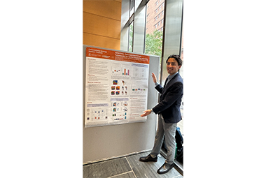 Jose Meza LIamosas standing by a poster