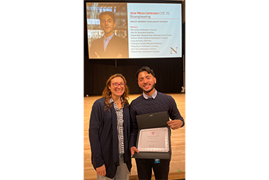 Jose Meza LIamosas standing with a women holding an award